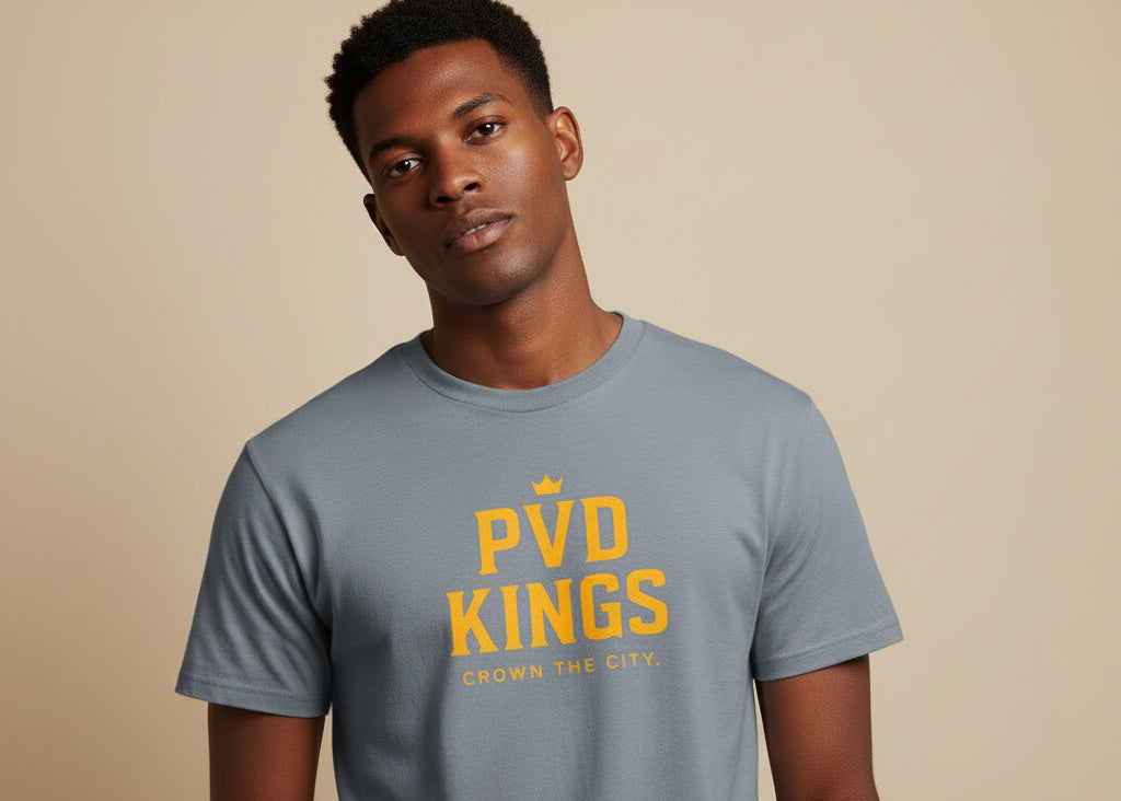 Man wearing a gray t-shirt with 'PVD Kings' text on a beige background